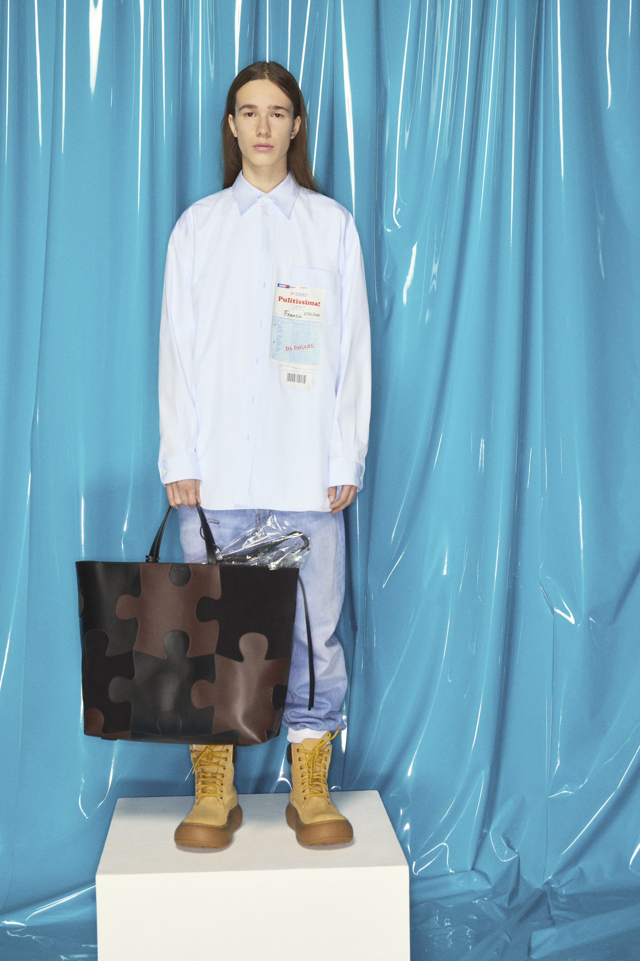 Moschino 26FW 以高度视觉化的“幽默符号”重申品牌精神，将玩具熊、笑脸图案、引号符号与拼贴针织转化为一种带有讽刺意味的时装语言。柔软针织与日常廓形承载强烈图像，使童真与荒诞并置，既像一场时尚游乐园，也是一种对当代消费文化的调侃。系列刻意拒绝克制美学，用直观情绪与符号刺激重新激活 Moschino 的反叛基因-顽石频道趋势研究